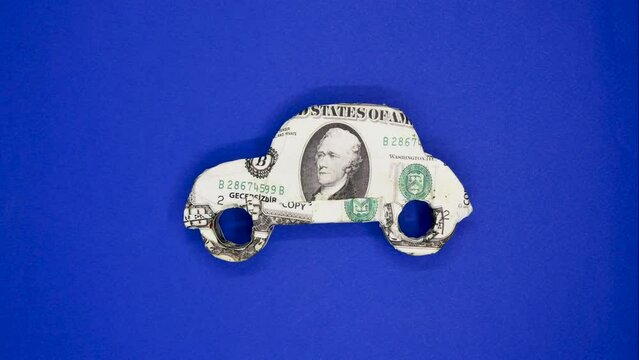 small car model with dollar banknote on blue background.Stop motion animation. 4k video capture