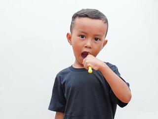 little asian boy brushing teeth on white background with copy space. children's dental health concept