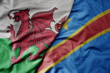 big waving national colorful flag of wales and national flag of democratic republic of the congo .