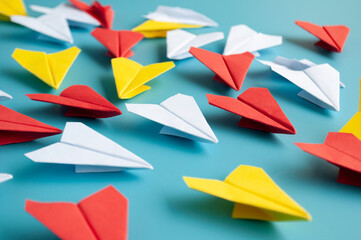 Yellow paper plane origami leading other white paper planes on blue background. Leadership concept. Origami concept.