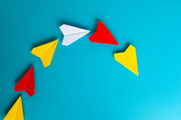 Top view of yellow paper plane origami leading other paper planes. With copy space.