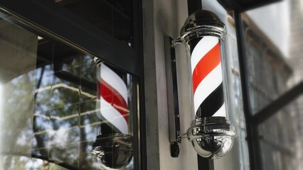 Close-up of a rotating barber shop pole. The barbershop logo rotates when entering the haircut studio.