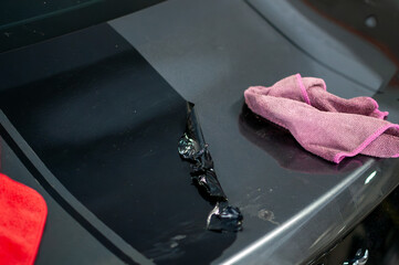 Tools for cleaning and polishing an expensive sports car in the garage. Removing stuck-on black stripes from vinyl wrap.