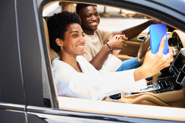 Joyful African American couple is sitting in a comfortable car