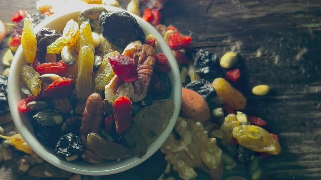 Mix Nuts in white ceramic bowl in a wooden Tabel top view.