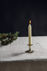 winter holidays and celebration concept - close up of candle burning on table and fir branch over black background - 648575682