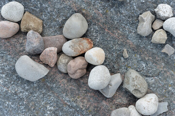 smooth rounded stones on rough dark gray rock