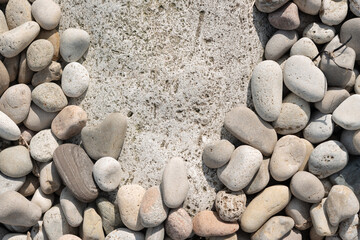 large pebbles resting comfortably around a large smooth stone surface