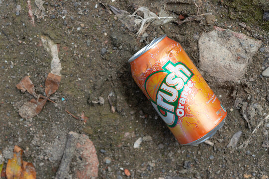empty orange crush can on the ground