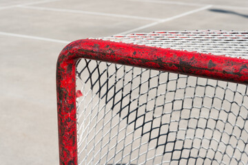 ball hockey net with worn grungy red frame in the park