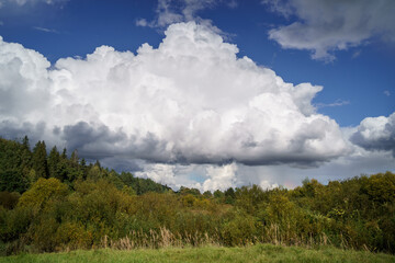 white rain clouds over countryside in summer