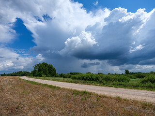 white rain clouds over countryside in summer