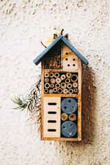 Cabane pour les insectes en bois sur un mur en pierre