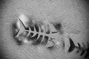 Pochoir sur un mur représentant un squelette de poisson drôle