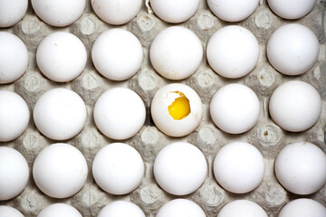 Eggs arrange in a tray with a Broken egg