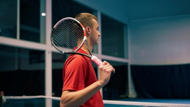 young man on an indoor tennis court hitting the ball with a racket in a jump serve during a game tennis instructor professional sport