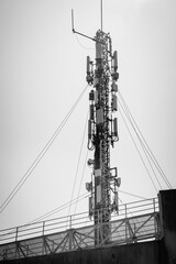 Black and white photograph of a huge telephone antenna installed on the roof of a building.
