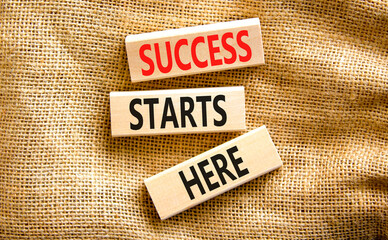Success starts here symbol. Concept word Success starts here on beautiful wooden block. Beautiful canvas table canvas background. Business motivational success starts here concept. Copy space.