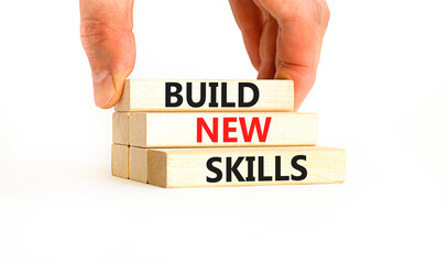Build new skills symbol. Concept word Build new skills on beautiful wooden block. Businessman hand. Beautiful white table white background. Business, education build new skills concept. Copy space.