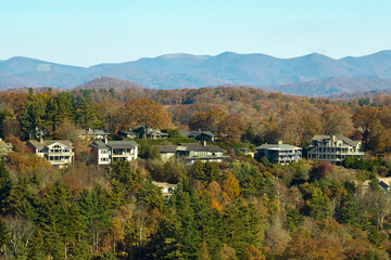Aerial view of big family houses on mountain top between yellow trees in North Carolina suburban...