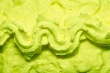 Cake cream texture, sweet whipped cream. Background of yogurt close-up with a pattern. Pistachio mousse.