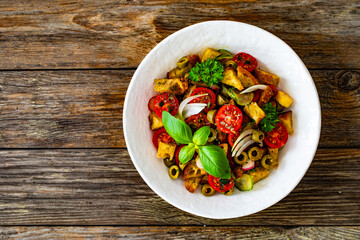 Italian style food - panzanella salad on wooden table
