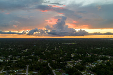 Aerial view of suburban landscape with private homes between green palm trees in Florida quiet residential area in evening