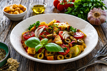 Italian style food - panzanella salad on wooden table

