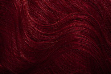 Dark red hair close-up as a background. Women's long brown hair. Beautifully styled wavy shiny curls. Coloring hair with bright shades. Hairdressing procedures, extension.