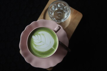 Close up a cup of Matcha green tea Latte art hot drink on wooden table background