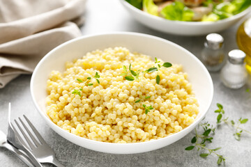 Couscous with chicken patties, cutlets with fresh romaine lettuce salad, top down view