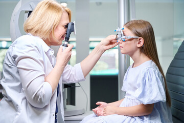 Orthoptist performing dynamic retinoscopy on little girl