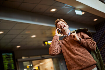 Middle aged businessman talking on the smartphone while waiting for his train at the train station