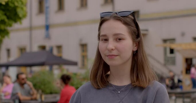 Youth portrait of teenage girl student in urban surroundings gazing into the camera. Student in urban environment. Youthful energy and curiosity, young woman on the cusp of adulthood. People lifestyle