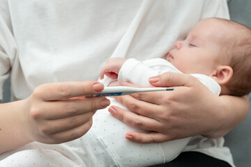 Thermometer reveals if infant has flu or fever. Concept of motherly precaution