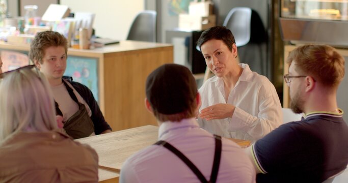 discusses life, plans, engages in lively debates, showcasing active involvement and creativity Social gathering in a cafe. Woman socializes, engaging in lively discussions, sharing thoughts and ideas