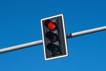 Red traffic light background. Isolated on blue sky. Stop light. Long metal pipe. Simple empty copy...