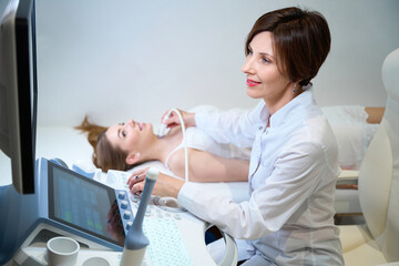 Uzist doctor conducts an ultrasound examination of a young female