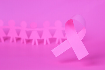 Pink Breast Cancer Awareness Ribbon. Pink paper ribbon bow with blur background of paper woman. October Pink day, world cancer day.