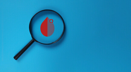 Magnifying glass with blood dropped icon on blue background for diabetes world day or blood donation day