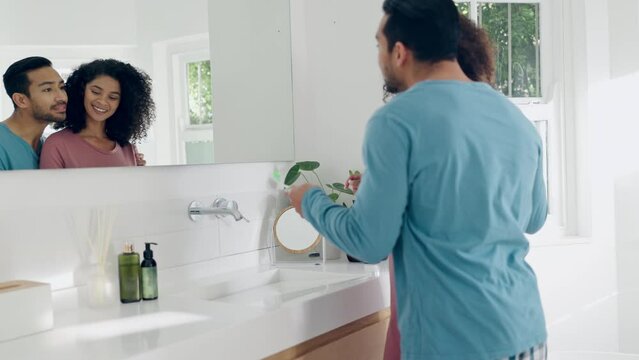 Love, hygiene and couple brushing teeth in the bathroom together on a weekend morning routine. Happy, hug and young man and woman doing treatment for dental health or oral care at modern apartment.