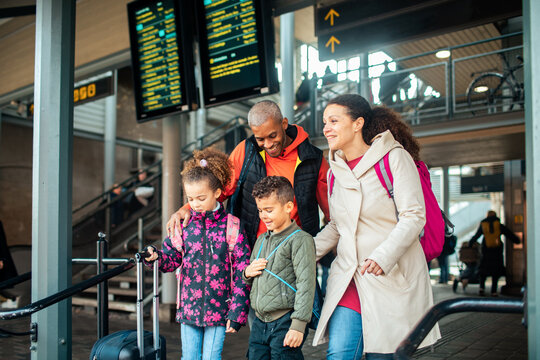 Young mixed family waiting for their train at the train station