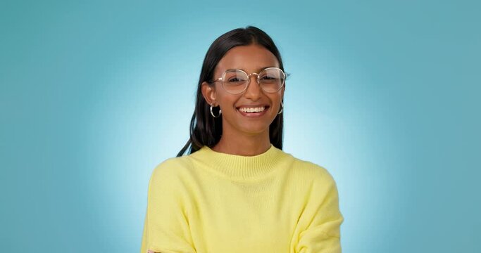 Woman, glasses and face with eye care in studio, smile and excited for choice, vision and fashion by blue background. Gen z girl, student and happy nerd with eyesight, prescription lens and frame