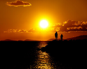 Intensive orange sunset with contrast black silhouette on the shiny background