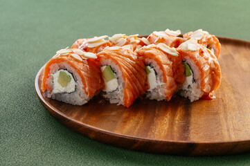 Sushi and soy sauce in a bowl and wooden chopsticks on a gray wooden table. Japanese food. 