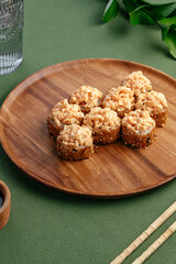 Sushi and soy sauce in a bowl and wooden chopsticks on a gray wooden table. Japanese food. 