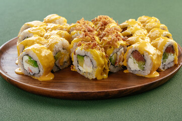 Sushi and soy sauce in a bowl and wooden chopsticks on a gray wooden table. Japanese food. 