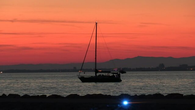 vue d'un coucher de soleil avec un yacht sur la plage du grau du roi
