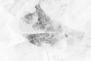 Close-up of snow on cracked and thin layers of ice in the winter. Simple and minimalistic abstract high key background in black and white with copy space.
