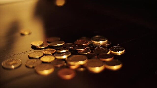 Slow motion, a pile of coins falls on a wooden table on a black background. Ukrainian pennies are falling a heap
